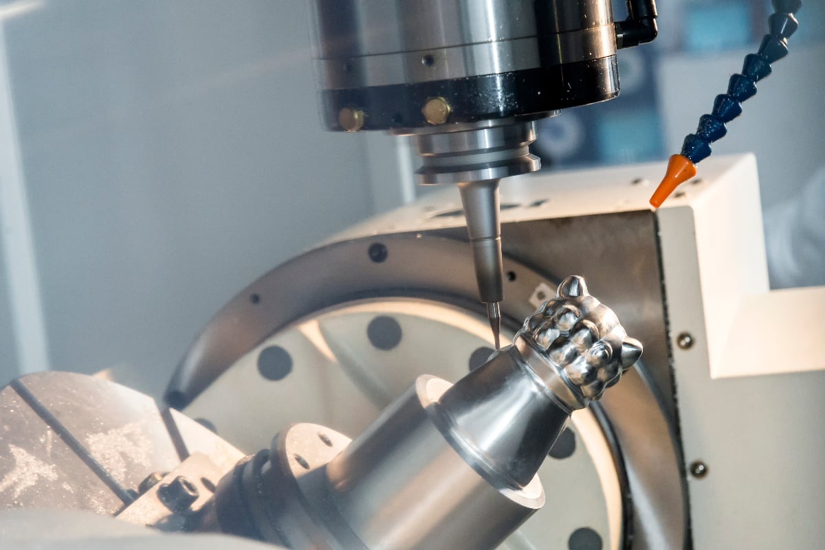 5-Axis CNC machine cutting a metal part using a solid ball-end milling tool.