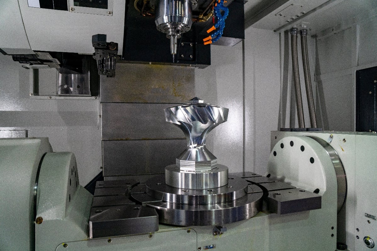 5-Axis CNC machine machining a complex metal part.